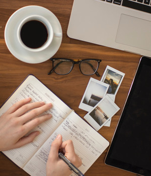 Photo of some one writing in their journal