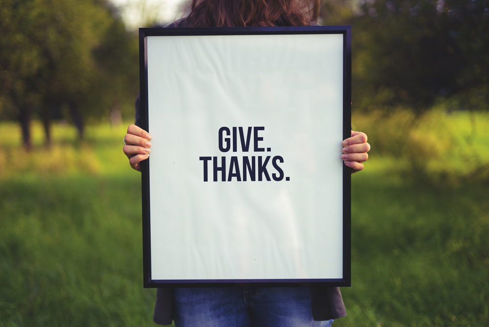 Photo of woman holding frame prompting to give thanks