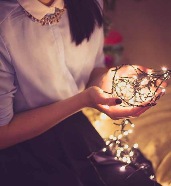 woman holding christmas lights