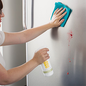 photo of woman cleaning refrigerator with Scentsy Clean