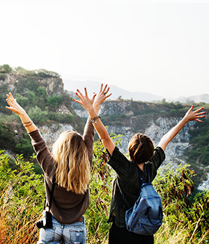 Photo of women with outstretched in a happiness on a cliff