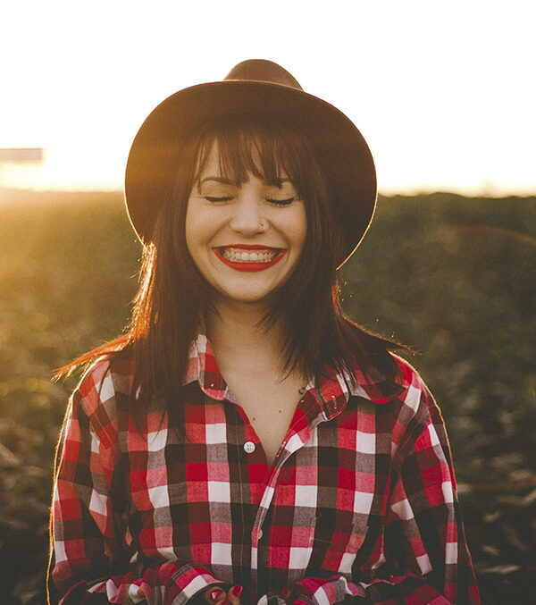 woman smiling in front of a sunset