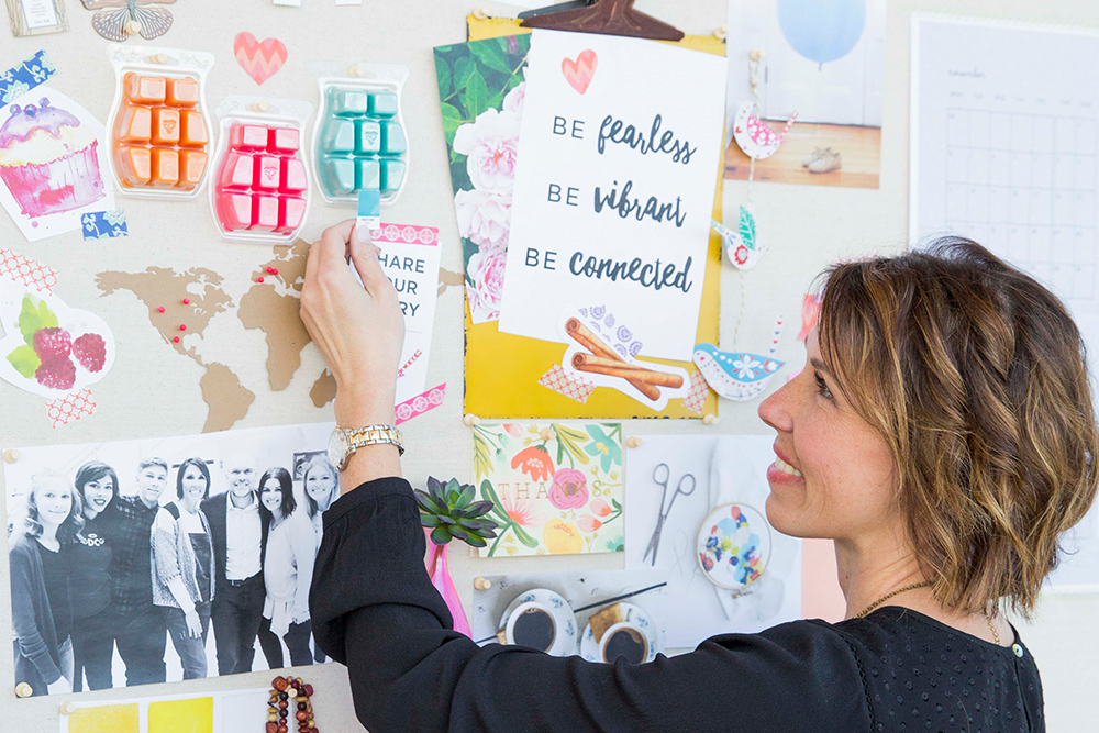 Photo of CEO Heidi matching a pantone in front of a Scentsy mood board