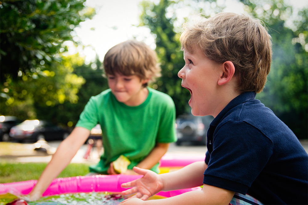 Photo of kids playing laughing in mini pool