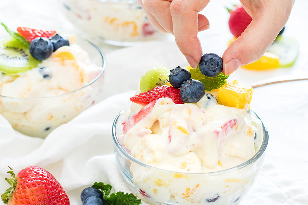 photo of woman preparing fruit salad cups