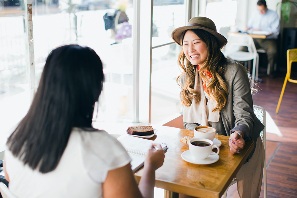 Scentsy counsultant happily talking to her friend over coffee