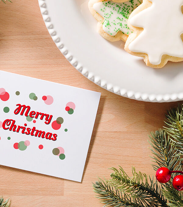 Photo of merry christmas card aside a plate of cookies