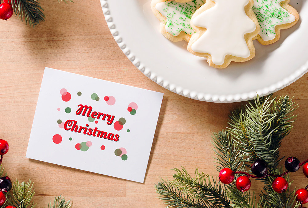 Photo of merry christmas card aside a plate of cookies