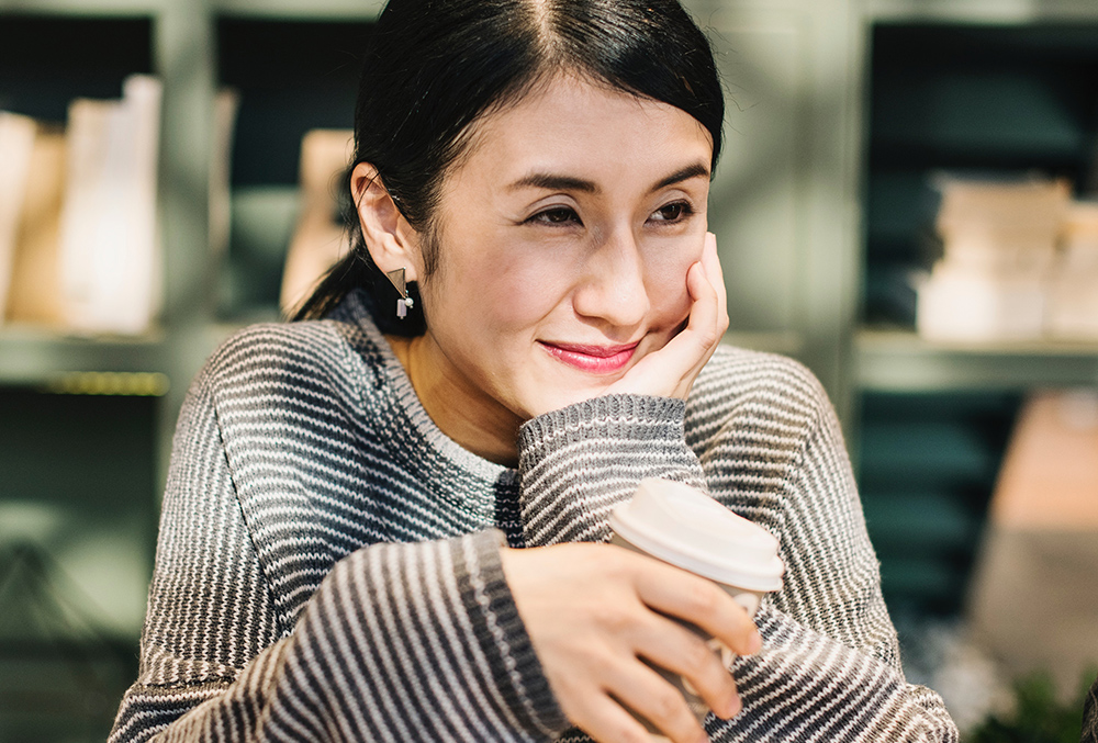 photo of woman reminiscing with cup of coffee