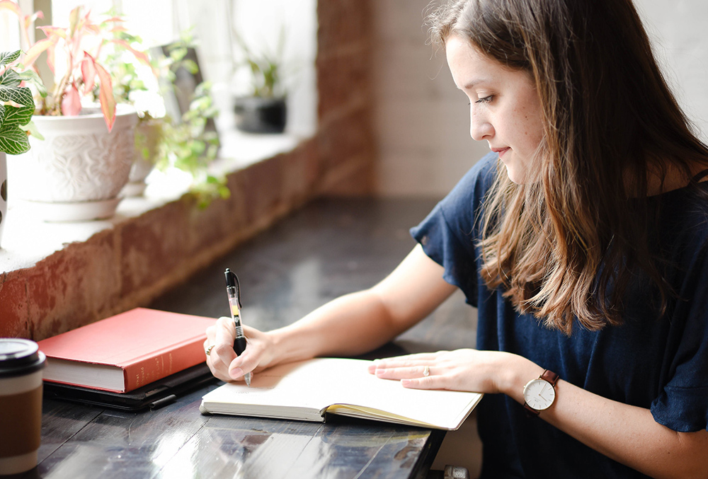 Photo of woman writing in planner