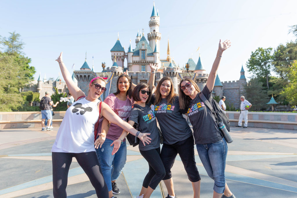happy group of consultants at disney world in front of Cinderella's castle