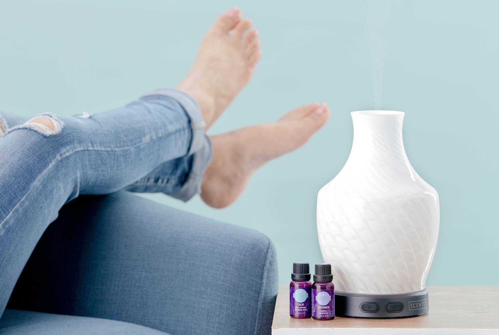 Woman relaxing on couch with her Scentsy diffuser warming Scentsy oils