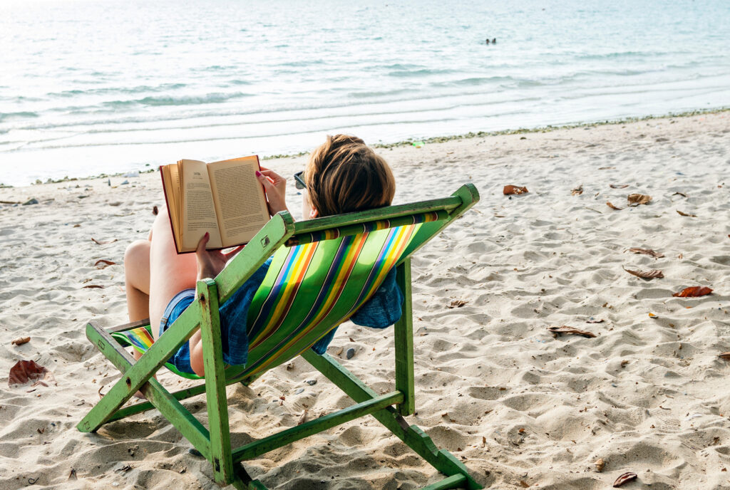 Woman reading a book on the beach