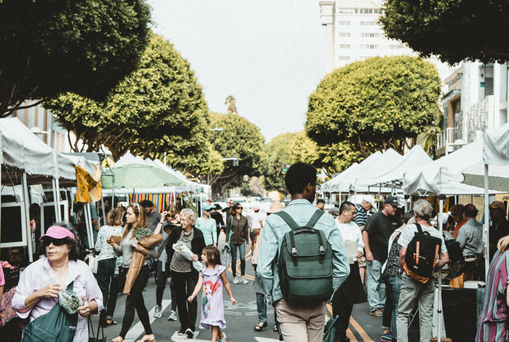 Farmers market with lots of people walking around