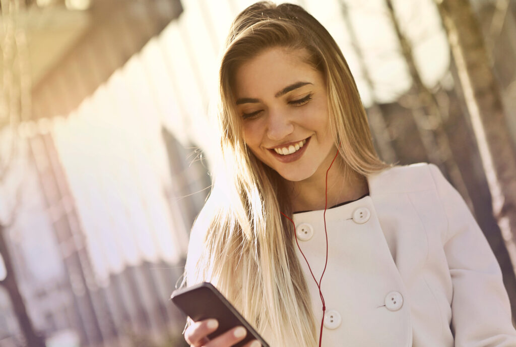 Woman smiling while listening to music through headphones