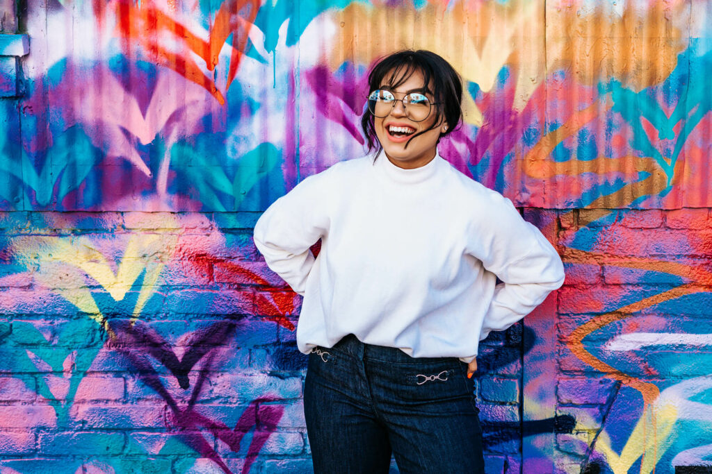 woman smiling in front of colorful wall