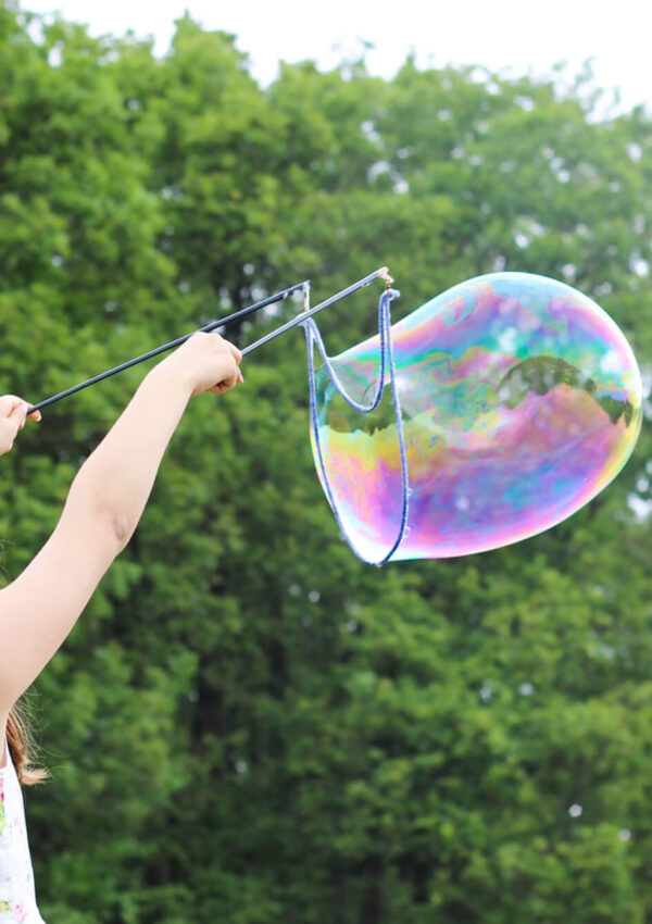 Girl making giant bubble in a park