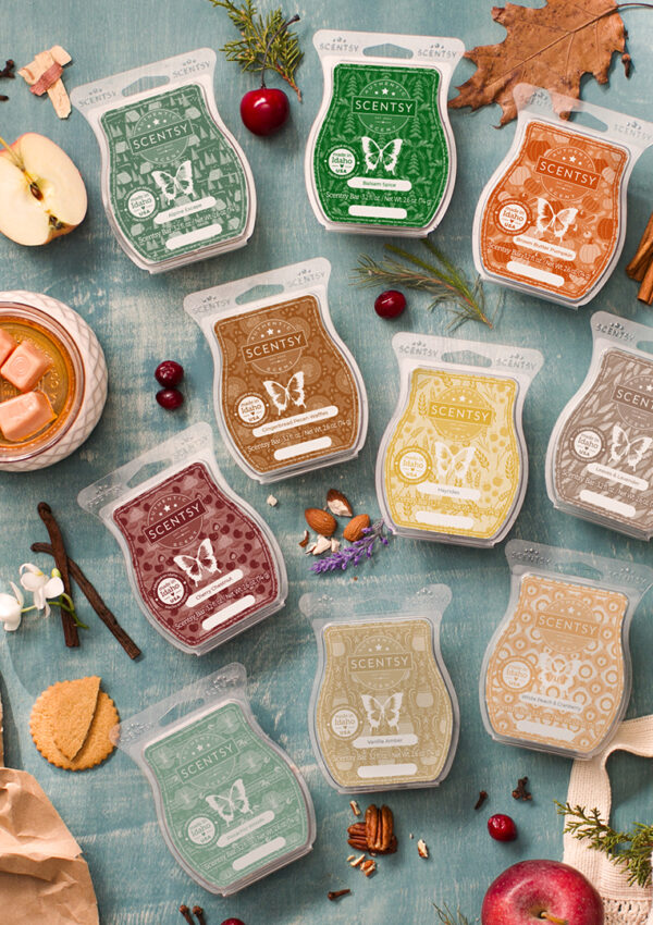 A large collection of Scentsy Wax Bars lying together on a table surrounded by fragrance notes