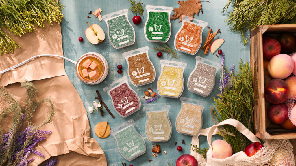 A large collection of Scentsy Wax Bars lying together on a table surrounded by fragrance notes