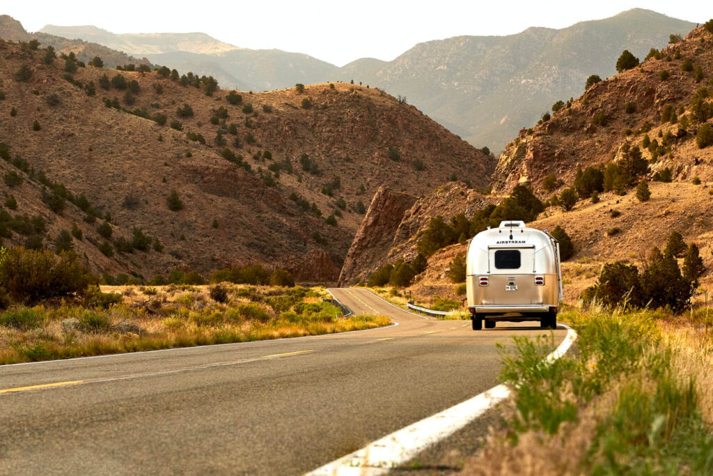 Silver camper driving through mountains