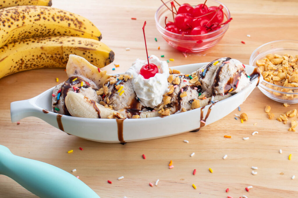 Banana split surrounded by the ingredients 