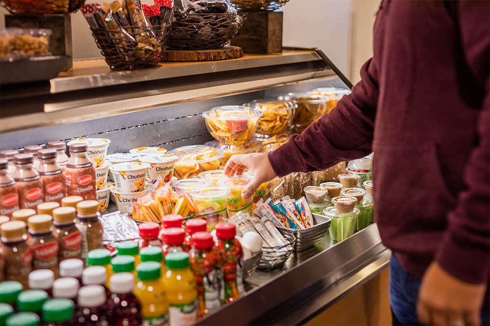 Person grabbing food from a mini open cooler