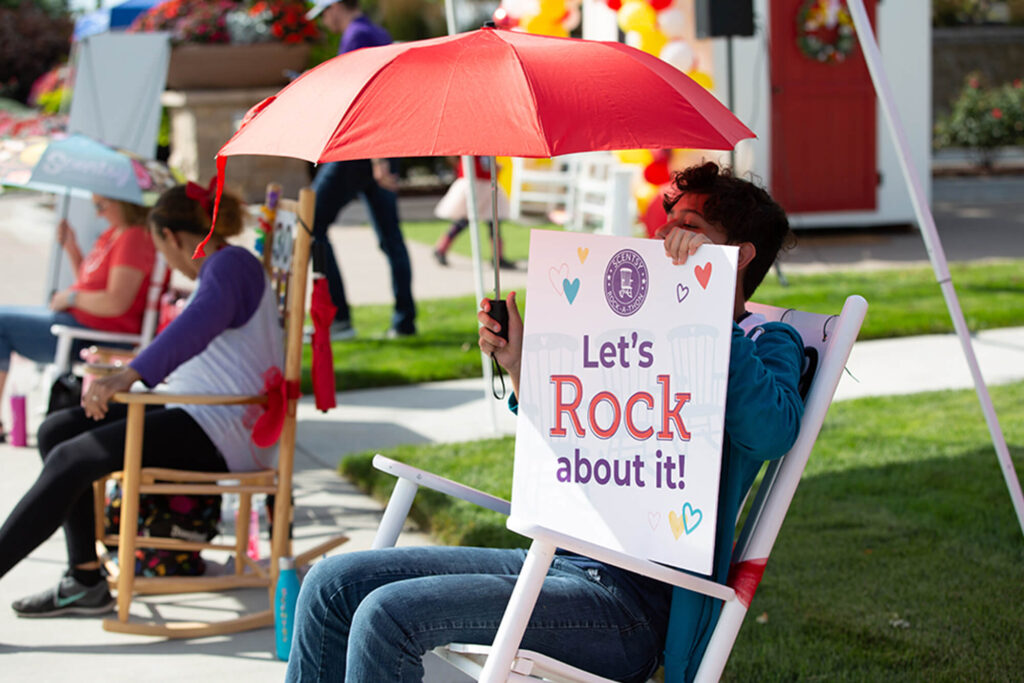 Scentsy Rock-a-Thon person rocking with a hand sign