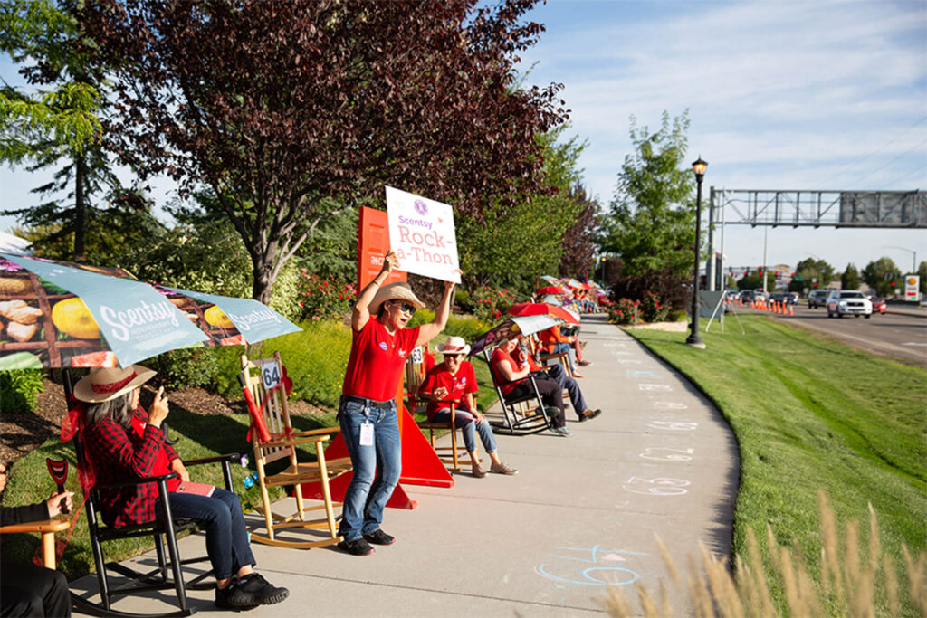 People rocking along the road holding up signs for the passing cars