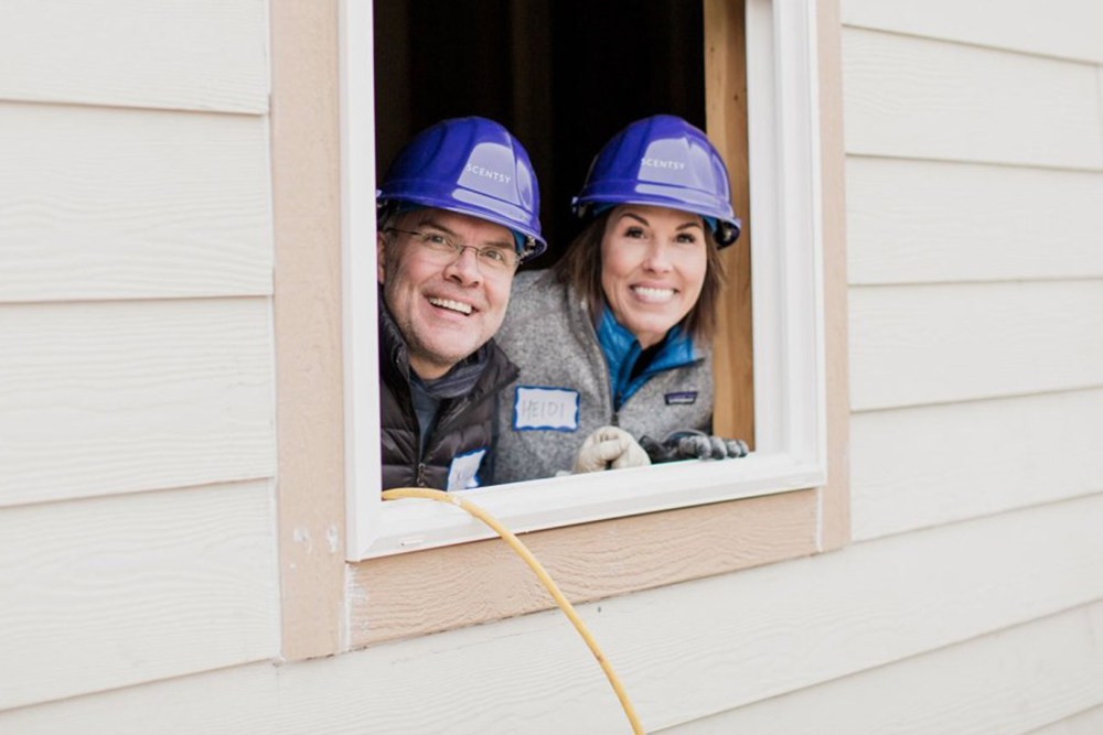 Heidi and Orville Thompson poking their heads out of a window