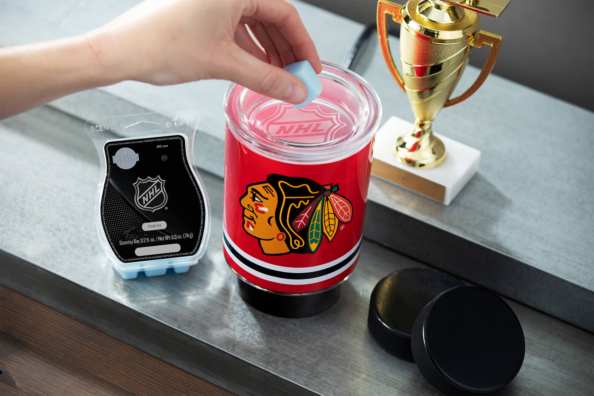 Scentsy NHL Blackhawks mini warmer with Fresh Ice wax with a trophy and hockey pucks nearby