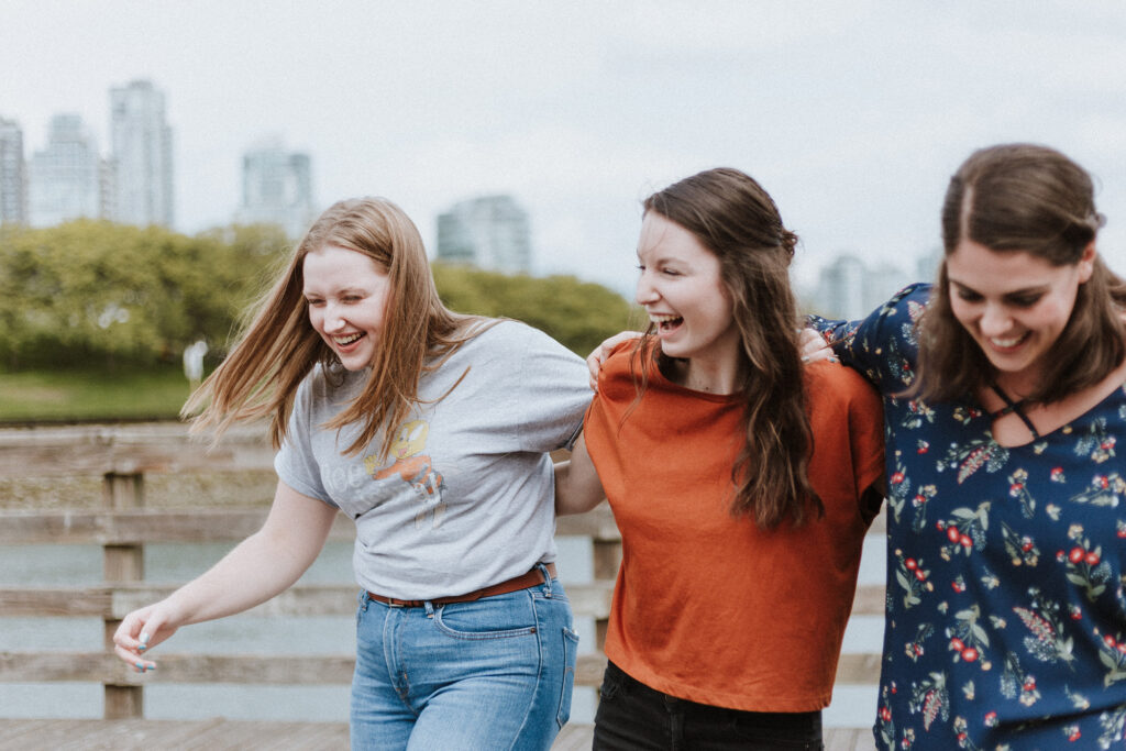 Three friends walking with a cityscape in the background