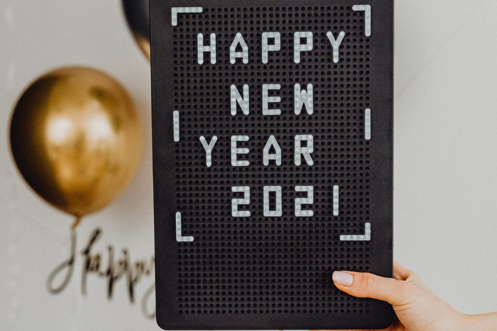 Person holding a sign saying "Happy New Year 2021"