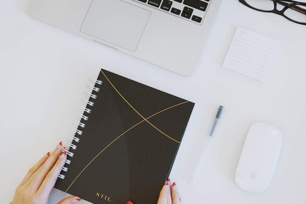 Person adjusting notebook on a highly organized desk