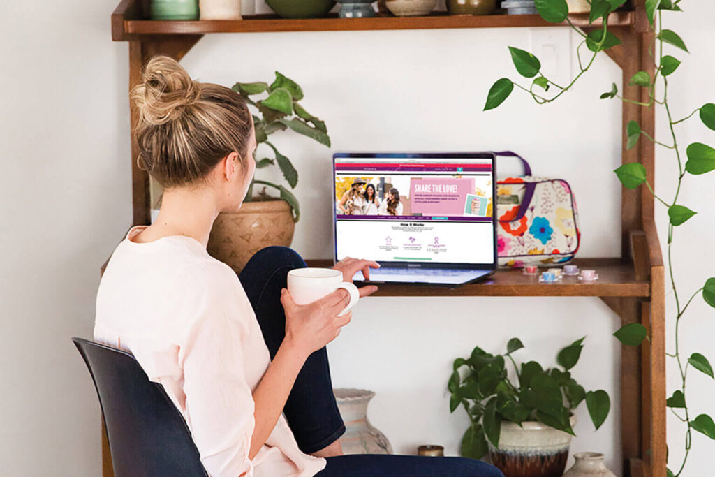 Woman looking at Scentsy home page at desk