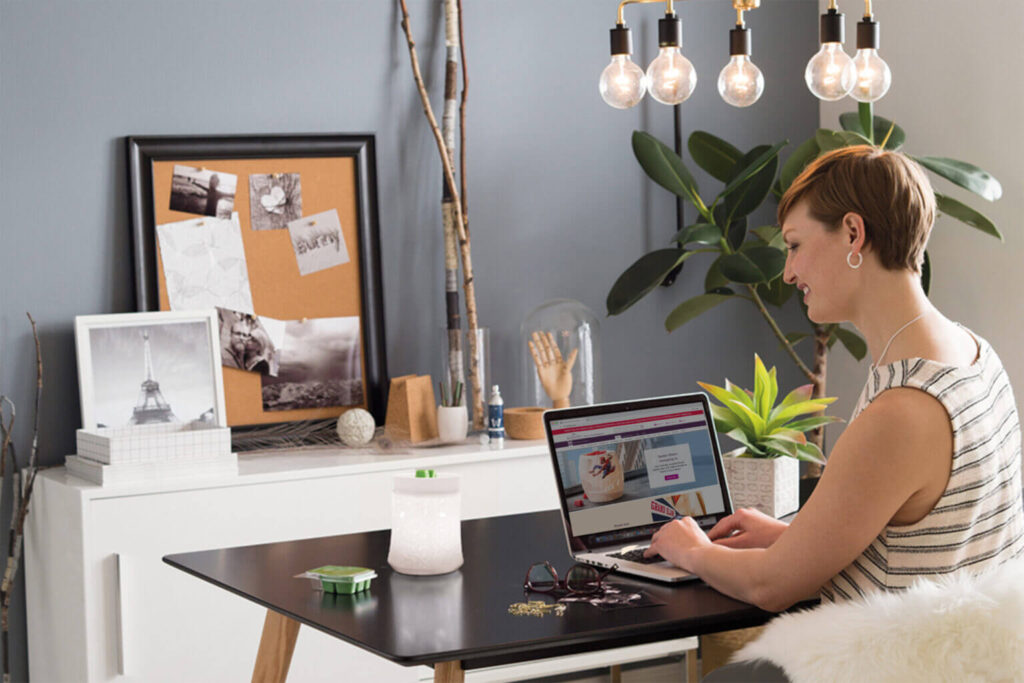 Person looking at Scentsy home page at desk