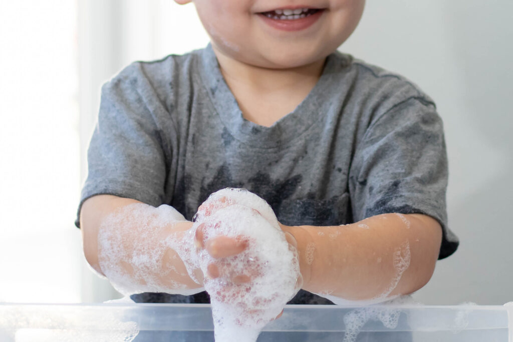 Child playing with soap suds