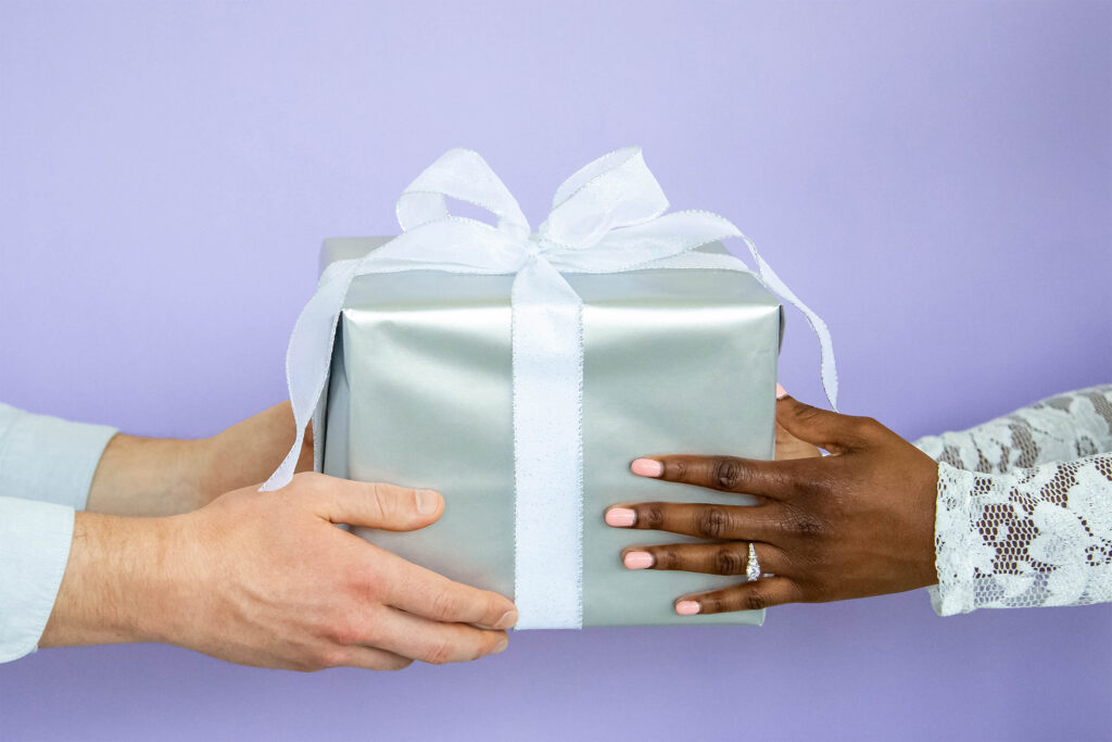 couple holding gift with a purple background