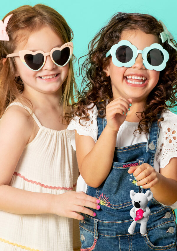 Two girls smiling with sunglasses while one girl holds the new Scentsy Best Friends Buddy Clip