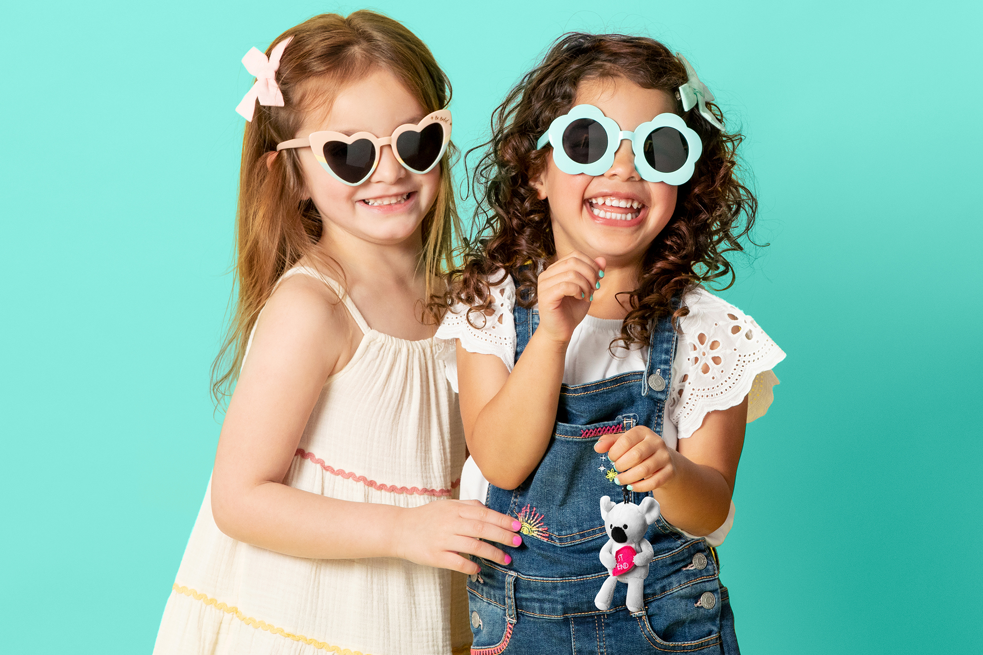 Two girls smiling with sunglasses while one girl holds the new Scentsy Best Friends Buddy Clip
