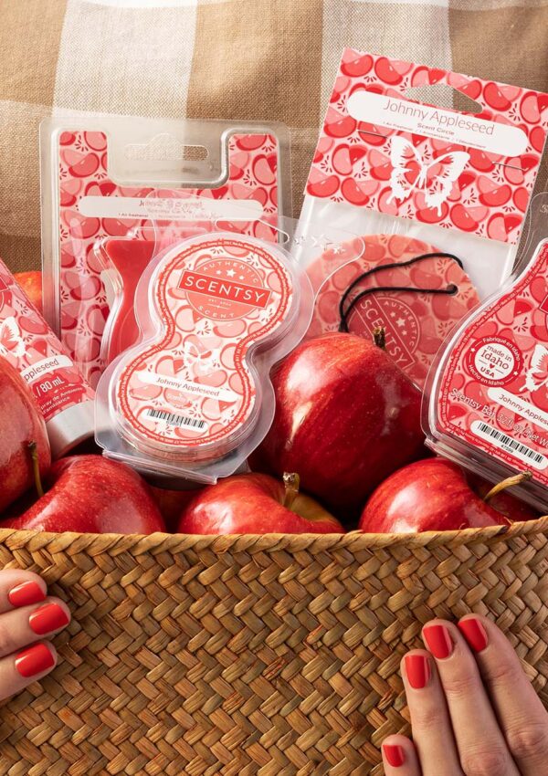 Person holding a basket filled with apples and scentsy red products