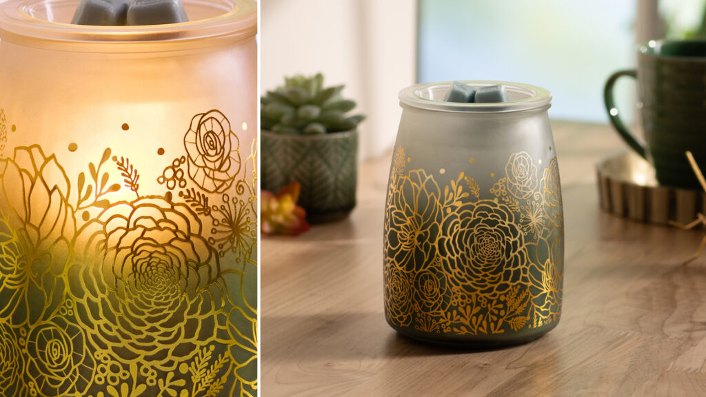 A closeup of the Charitable Cause Tranquil Glow Warmer that highlights the shining gold-colored floral designs and the green to cream color gradient.