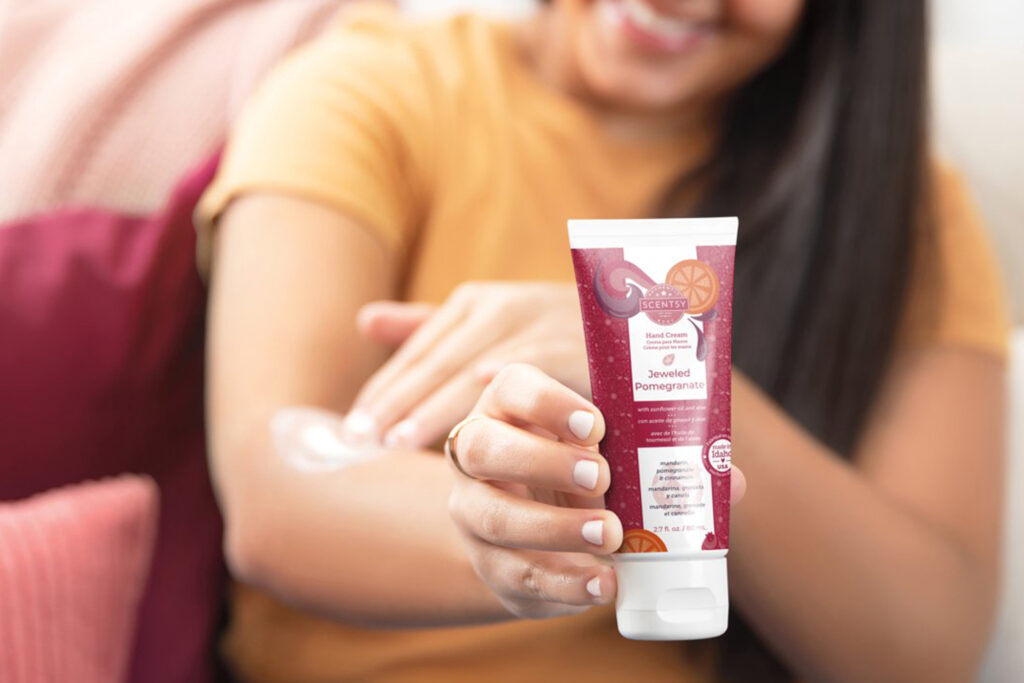Woman holding Scentsy Hand Cream scented in Jeweled Pomegranate