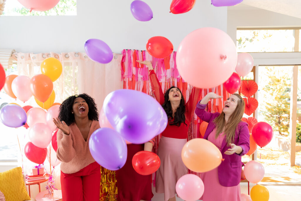 Girl friends throwing around balloons and having fun for Galentine's Day