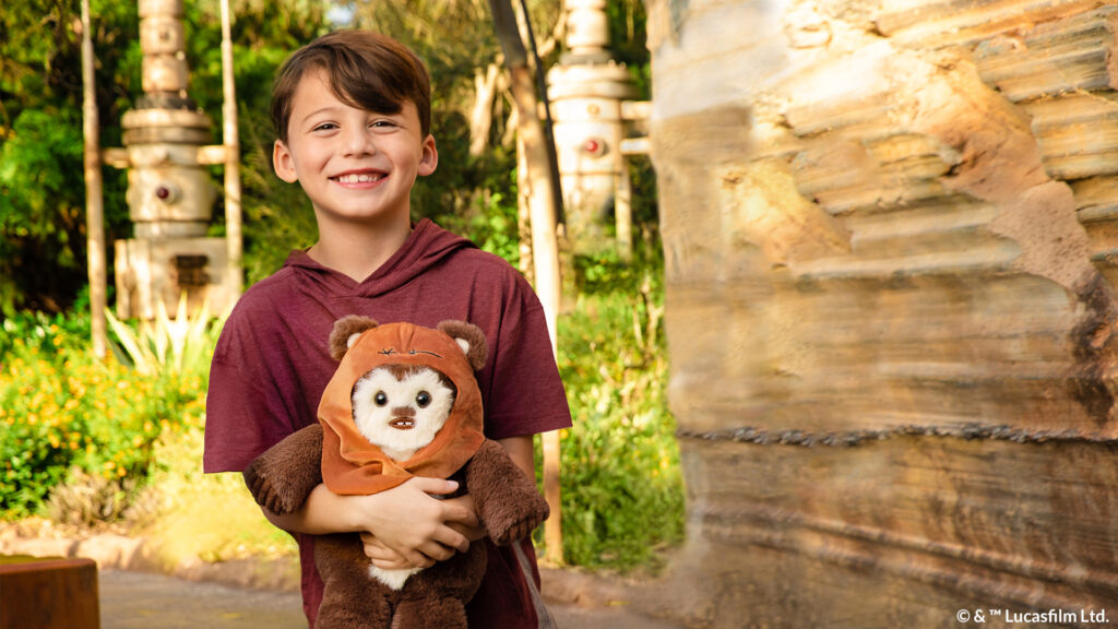Kid holding an Ewok Scentsy Buddy stuffed animal from the Star Wars collection