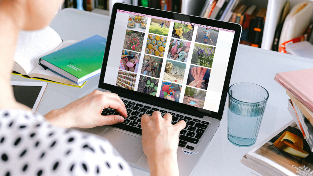 A woman on her laptop sorting through all of her captured photos to use for scrapbooking