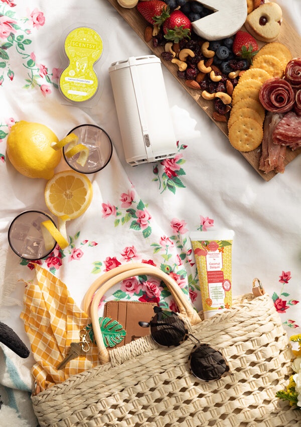 Summer picnic full of scentsy portable scent products, fruits and a charcuterie board on a floral white linen