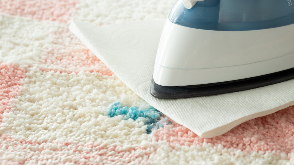 The heat and blot wax removal method using an iron with a paper towel under it and running it over the wax on the carpet to get out the wax spill