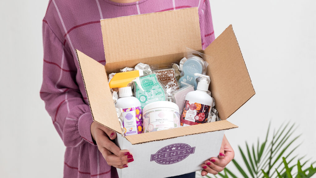 An opened package containing a woman's Scentsy Club order full of Scentsy scent products in their subscription box