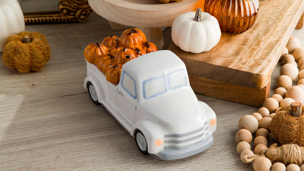 Retro truck warmer with a pumpkin lid surrounded by fall home décor that can be changed to a Christmas tree lid for christmas time