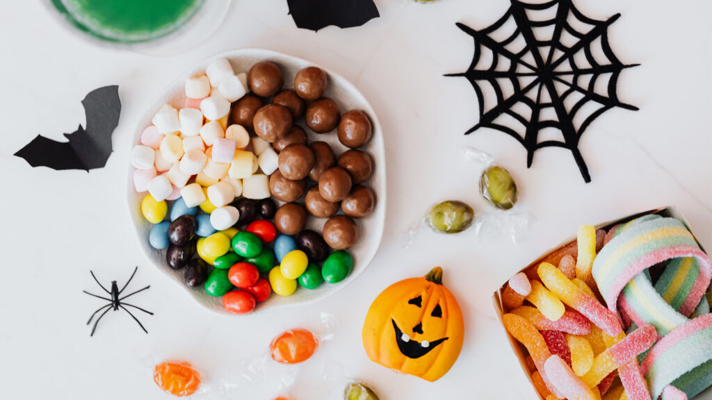 A food display of different halloween candies and halloween creature cutouts
